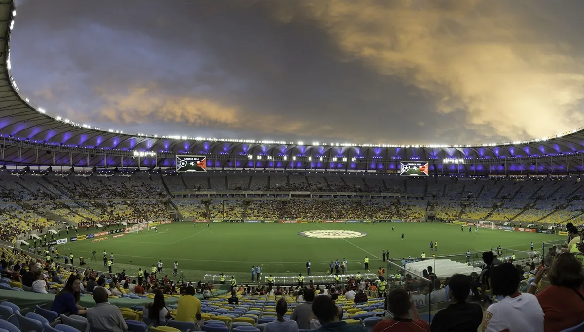 Interior de estádio de futebol lotado sob céu nublado